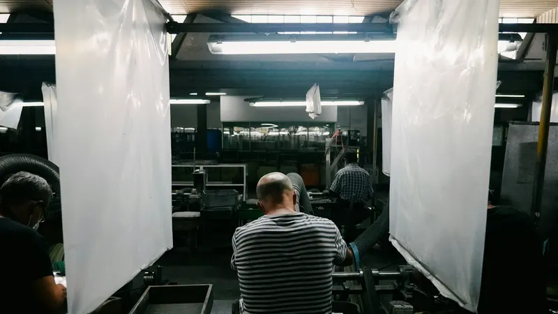 Pracownicy przy linii produkcyjnej w zakładzie